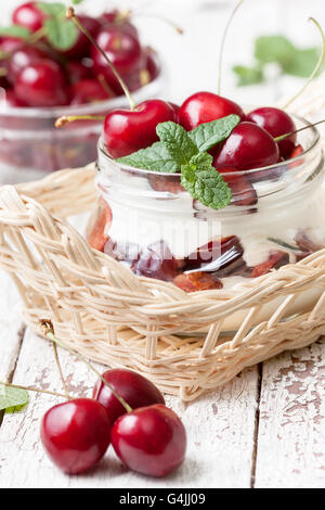 Yogurt with fresh sweet cherries in a glass jar. Dietary breakfast. Stock Photo