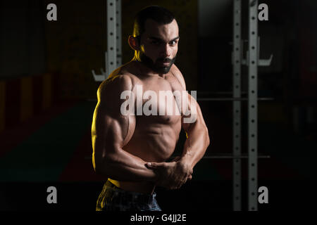 Portrait Of A Young Physically Fit Man Performing Side Chest Pose - Muscular Athletic Bodybuilder Fitness Model Posing After Exe Stock Photo
