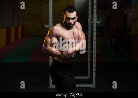 Portrait Of A Young Physically Fit Man Performing Side Chest Pose - Muscular Athletic Bodybuilder Fitness Model Posing After Exe Stock Photo
