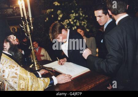 Prince William, older son of Britain's Prince of Wales, signs the christening book for his first godson, Prince Konstantine Alexios, son of Crown Prince and Princess Pavlos, at the Greek Cathedral in Central London. Prince William is one of eight godparents. * drawn from friends of the family and the European Monarchy. Although left-handed, the Prince used his right hand to sign the book, as he is recovering from an operation on a broken finger on his left-hand. Stock Photo