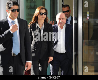 Russian oligarch Boris Berezovsky (second right) leaves the Commercial Court of the High Court in central London, with girlfriend Yelena Gorbunova and security guards. Stock Photo