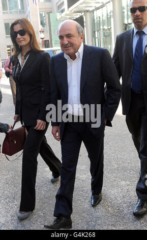 Russian oligarch Boris Berezovsky (centre) leaves the Commercial Court of the High Court in central London, with girlfriend Yelena Gorbunova and security guards. Stock Photo