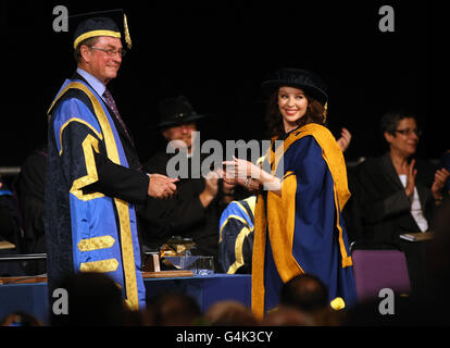 Singer Kylie Minogue, smiles as she receives her honorary degree from University Chancellor Lord Ashcroft at Anglia Ruskin University in Chelmsford, Essex. Stock Photo