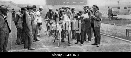 Cyclists, surrounded by team members, volunteers and officials, about to set off for the Individual Time Trials during the 1924 Paris Olympics. Stock Photo