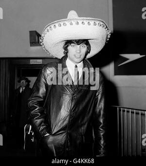 Manchester United footballer George Best wearing a Souvenir Sombrero on his return to London airport following United's defeat of Benfica 5-1 in the second leg of the European Cup quarter final football match. Best scored United's first two goals. Stock Photo