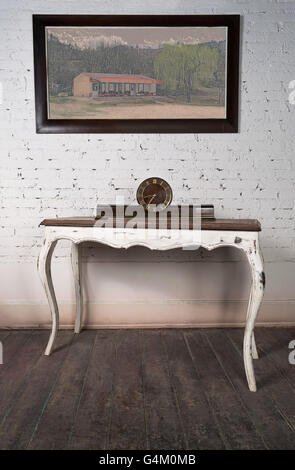 Old retro desktop clock placed on white vintage wooden table Stock Photo