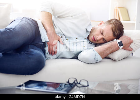 Sick man lying on the couch Stock Photo