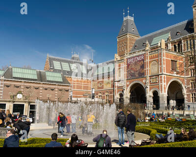 People gather outside Amsterdam's Rijksmuseum to play in a garden fountain on a beautiful spring day. Stock Photo