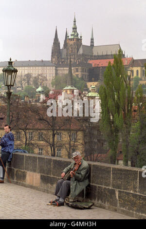 A musician plays on the Charles Bridge in Prague in the shadow of the city's castle and St Vitus Cathedral. The Prince and Princess of Wales arrive in Czechoslovakia's capital tomorrow for an official visit Stock Photo