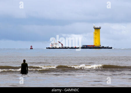 Shipping leaving the River Mersey, crossing the Burbo Windfarm, at Crosby, Merseyside, UK. Cammell Laird is used as a base port for the construction of the Gwynt y Môr wind farm components n the Irish Sea. The port area covers around 14 hectares 32 acres and includes a quay of 230 metres. It is from here that the foundations for 160 wind turbines are preassembled, loaded and shipped to the 576 megawatt wind farm in Liverpool Bay positioned around 18 kilometres off the Welsh coast. Stock Photo