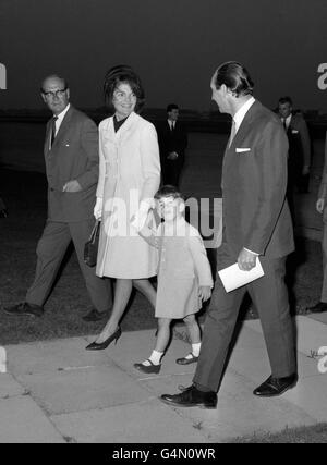Mrs. Jackie Kennedy, holding the hand of her son, John Jr, smiles as she walks from the U.S. Presidential aircraft after landing at London Airport. She has flown over with her two children to attend the unveiling by the Queen of a memorial to her assassinated husband, President John F Kennedy. Stock Photo