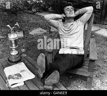 The day after winning the British Open Golf Championship at the Royal Lytham and St. Anne's, Tony Jacklin relaxes with his silver trophy alongside him in the back garden of his father, a lorry driver who lives near Scunthorpe, Lincolnshire. Stock Photo