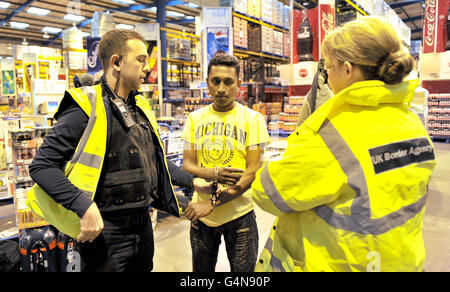 A customer (name not known) at Bestway Cash and Carry in Liverpool is arrested by UK Border Agency officers. PRESS ASSOCIATION Photo. Picture date: Thursday November 10, 2011. Two illegal immigrants were held when Border Agency officials raided the city centre cash-and-carry. A Pakistani man, aged 22, and a 22-year-old Iraqi man were found to be working illegally. The pair are expected to be deported. See PA story POLICE Raid. Photo credit should read: Martin Rickett/PA Wire Stock Photo