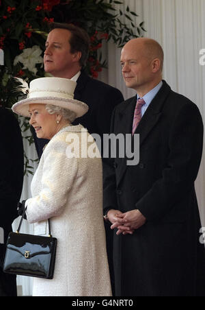 Queen Elizabeth II stands beside Prime Minister David Cameron and Foreign Secretary William Hague as they await the arrival of Turkish President Abdullah Gul at Horse Guards Parade in London as Gul begins a three day State Visit to the UK. Stock Photo