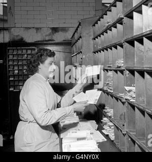 Mrs Elsie Ives of the General Post Office at St. Martin's-le-Grand, London, handles letters to 'Santa Claus' as the Christmas mail starts coming through Stock Photo