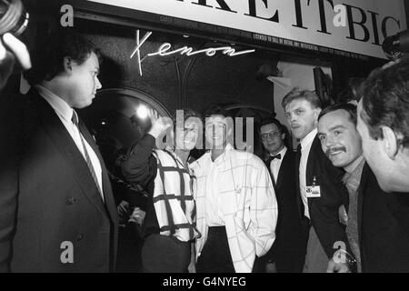 Pop stars George Michael (waving ) and Andrew Ridgeley, who make up the band Wham!, arrive at a club in Piccadilly, London, to launch their second album 'Wham! Make it Big'. Stock Photo