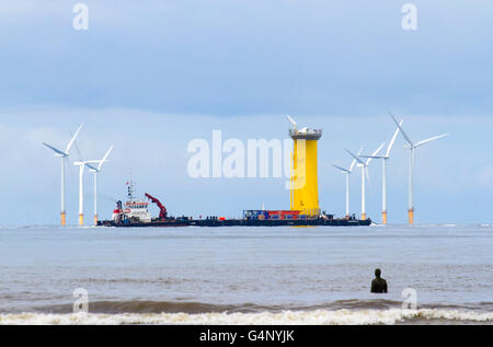 Shipping leaving the River Mersey, crossing the Burbo Windfarm, at Crosby, Merseyside, UK. Cammell Laird Wind Farm components. Stock Photo