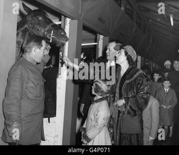 Queen Elizabeth II and Princess Anne view circus horses in their stalls when they attended the afternoon performance of Bertram Mills Circus at Olympia, London. Cyril Mills is left of the Queen. Stock Photo