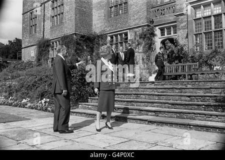 Prime Minister Margaret Thatcher and French President Francois Mitterrand indicate the flower borders at Chequers which they discussed when she showed him round the grounds of her official country residence in Buckinghamshire. He was there for routine twice-yearly bilateral talks and was accompanied by his Foreign Minister, Roland Dumas (centre in background group) who was there for talks with Foreign Secretary John Major (right of group). Stock Photo