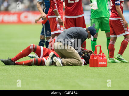 Vancouver, Canada. 18 June, 2016. New England Revolution forward Kei Kamara (13)  is being  tended to after a collision. Vancouver Whitecaps vs New England Revolution, BC Place Stadium.  Final Score New England wins 2-1. Credit:  Gerry Rousseau/Alamy Live News Stock Photo