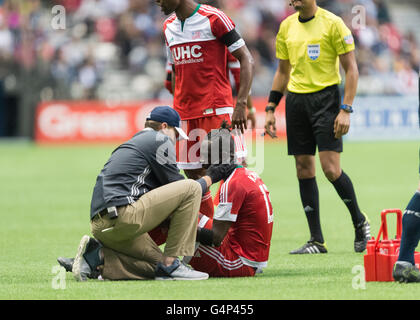 Vancouver, Canada. 18 June, 2016. New England Revolution forward Kei Kamara (13), is being tended to after an injury. Vancouver Whitecaps vs New England Revolution, BC Place Stadium.  Final Score New England wins 2-1. Credit:  Gerry Rousseau/Alamy Live News Stock Photo