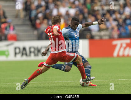 Vancouver, Canada. 18 June, 2016. New England Revolution midfielder Kelyn Rowe (11) challenging Vancouver Whitecaps defender Jordan Smith (6). Vancouver Whitecaps vs New England Revolution, BC Place Stadium.  Final Score New England wins 2-1. Credit:  Gerry Rousseau/Alamy Live News Stock Photo