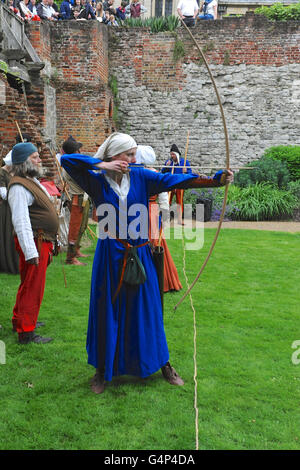 Greenwich, London, UK. 18th June, 2016. A female re-enactor dressed using a longbow during a re-enactment in Greenwich, London, UK. The 'Grand Medieval Joust' was held at Eltham Palace, an English Heritage property which was the home of King Henry VIII as a child. The event aims to give an insight into life at the palace during the medieval period. Credit:  Michael Preston/Alamy Live News Stock Photo