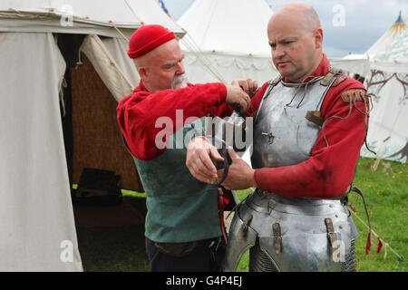 Greenwich, London, UK. 18th June, 2016. A re-enactor getting into  armour before staging a medieval battle in Greenwich, London, UK. The 'Grand Medieval Joust' was held at Eltham Palace, an English Heritage property which was the home of King Henry VIII as a child. The event aims to give an insight into life at the palace during the medieval period. Credit:  Michael Preston/Alamy Live News Stock Photo