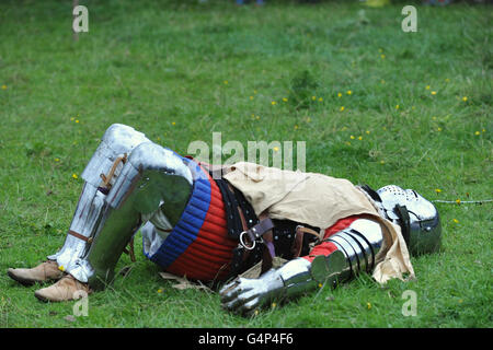 Greenwich, London, UK. 18th June, 2016. A re-enactor dressed as a medieval man at arms lying on the grass during a re-enactment in Greenwich, London, UK. The 'Grand Medieval Joust' was held at Eltham Palace, an English Heritage property which was the home of King Henry VIII as a child. The event aims to give an insight into life at the palace during the medieval period. Credit:  Michael Preston/Alamy Live News Stock Photo