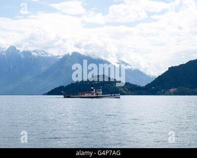 Lake Como, Italy. 18th June, 2016. Old boat passengers traveling on the lake. In the background the mountains of Valtellina. Stock Photo
