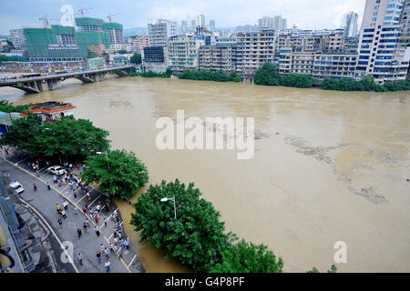 Chongqing, China. 19th June, 2016. People stand on the Binjiang Road along the Qijiang River in Chongqing, southwest China, June 19, 2016. Local flood control and drought relief authorities initiated a Level IV emergency response Sunday noon to cope with the possible flooding after torrential rain hit the city from June 18 to 19. Credit:  Chen Xingyu/Xinhua/Alamy Live News Stock Photo
