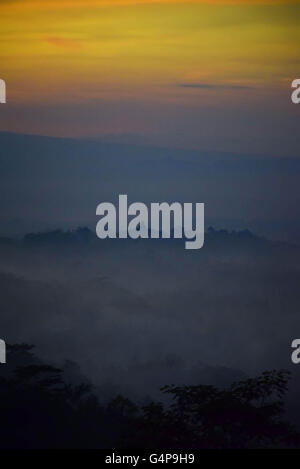 June 18, 2016 - Magelang, Central Java, Indonesia - CENTRAL JAVA, INDONESIA - JUNE 18 : A view of Borobudur temple on sunrise on June 18, 2016 in Magelang, Central Java, Indonesia. Borobudur, or Barabudur, is a 9th-century Mahayana Buddhist Temple in Magelang, Central Java, Indonesia. The monument consists of nine stacked platforms, six square and three circular, topped by a central dome. The temple is decorated with 2,672 relief panels and 504 Buddha statues. The central dome is surrounded by 72 Buddha statues, each seated inside a perforated stupa. It is the world's largest Buddhist temple,  Stock Photo