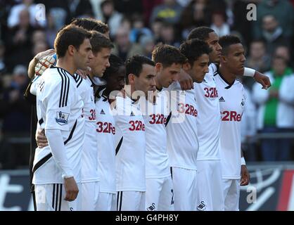 Swansea City Wales players Joe Allen (4th Right), Neil Taylor (3rd right) and Ashley Williams (2nd right) along with their team mates observe a minutes silence after the news that Wales manager Gary Speed has died Stock Photo