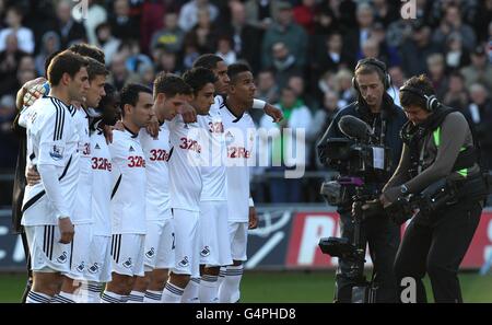 Swansea City Wales players Joe Allen (4th Right), Neil Taylor (3rd right) and Ashley Williams (2nd right) along with their team mates observe a minutes silence after the news that Wales manager Gary Speed has died Stock Photo