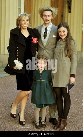 Sam Taylor-Wood proudly wears her OBE with partner Aaron Johnson and her children Angelica (right) and Jessie, after it was presented to her by the Prince of Wales during the Investiture Ceremony at Buckingham Palace in central London. Stock Photo