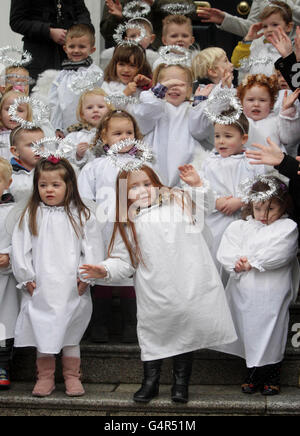 Children dressed as angels, from St Josephs Nursery, sing Christmas carols as the traditional Live Animal Crib, supplied by the Irish Farmers Association, opens at the Mansion House in Dublin. Stock Photo