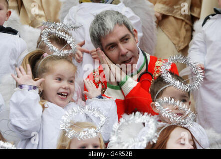 Lord Mayor Andrew Montague joins children dressed as angels, from St Josephs Nursery, for the singing of Christmas carols as the traditional Live Animal Crib, supplied by the Irish Farmers Association, opens at the Mansion House in Dublin. Stock Photo