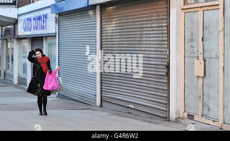 A shopper walks past closed shop fronts in George Street, Altrincham, Cheshire as moves to revitalise high streets and shopping centres struggling to attract customers will be revealed today, including plans for a national market day and relaxation of rules to make it easier to set up street stalls. Stock Photo