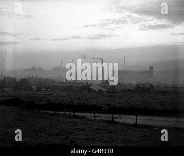 PA Photo: OLDHAM, CIRCA 1956. A library file picture of housing and factories in Oldham, Lancashire, taken from the Pennines. A heavy smog hangs over the area. Stock Photo