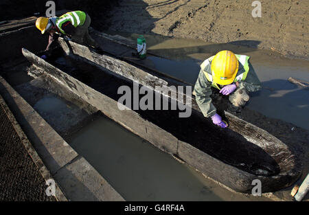 Site Assistants Emma Rees (right) and Iona Robinson work on a Bronze Age long boat unearthed along the old course of the River Nene at Must Farm quarry in Whittlesey, Cambridgeshire. Stock Photo