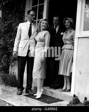 Marilyn Monroe, with her husband Arthur Miller, Sir Laurence and Lady Olivier behind them, at Parkfield House, Englefield Green, Surrey, where they stayed during their visit. Monroe was there to make the film 'The Sleeping Prince' with Sir Laurence at Pinewood. Stock Photo