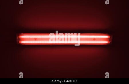Detail shot of a fluorescent red light tube on a wall with copyspace. Stock Photo