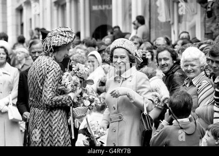 Queen Elizabeth II hands posies to her Lady in Waiting, the Duchess of Grafton, and poses for a photograph, on a walkabout in St Peter Port, during her visit to the island of Guernsey, Channel Islands. Stock Photo