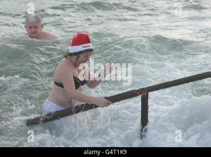 Photo. Hundreds of people at the annual Forty Foot Christmas Day Swim at Sandycove, Dublin. Stock Photo