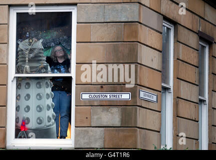 Doctor Who fan Erica Quinn looks out from her window after she turned her house into her very own Tardis. Life sized cardboard cut-outs of the Tenth and Eleventh incarnations of the Doctor, as played by Matt Smith and David Tennant, companions Amy Pond (Karen Gillan) and time agent Captain Jack (John Barrowman), and a sly Dalek peer put from behind the curtains of the flat-turned-Tardis. Mrs Quinn dresses them up on special occasions like Christmas, Thanksgiving, Halloween and Easter - giving each a costume. Stock Photo