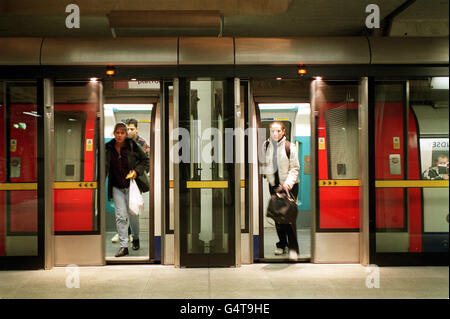 Passengers alight from a train through open glass barriers on the platform at Bermondsey tube station, designed by Ian Ritchie Architects, now open as part of the London Underground Jubilee line extension. * Glass barriers have been introduced on the platforms to increase the speed of trains on the line by reducing the flow of air through the tube tunnels. Stock Photo