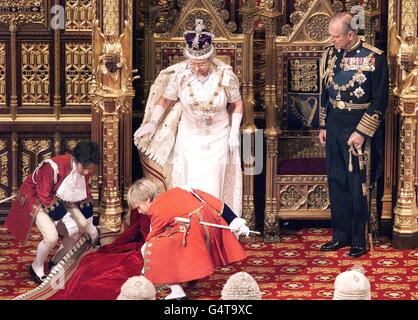 Britain's Queen Elizabeth II has her robe's train adjusted bu young pageboys on her entrance to the State Opening of Parliament 17 November 1999 in the House of Lords. The Queen made her opening speech in which she outlined what her government proposes to introduce to parliament and marks the opening of the session. Stock Photo