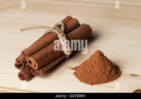 Close-up of cinnamon sticks and powder on a wooden table Stock Photo