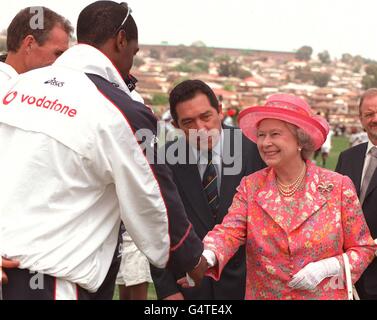 The Queen with South African Cricket boss Ali Bacher (C) shakes hands with England cricketer Alex Tudor while on a visit to the Alexander Township cricket ground, north of Johannesburg, South Africa. * The Queen is on a state visit ahead of the Commonwealth Heads of Government Meeting in Durban. Stock Photo