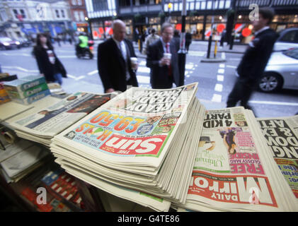 A selection of newspapers at a news stand in central London, on the day former Sun editor Kelvin MacKenzie gave evidence to the Leveson Inquiry. Stock Photo